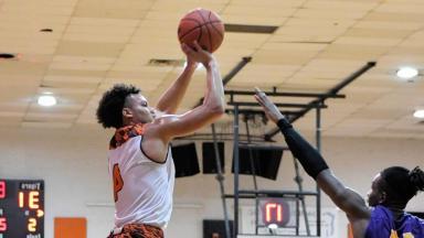 Basketball Player Shoots Over Defender